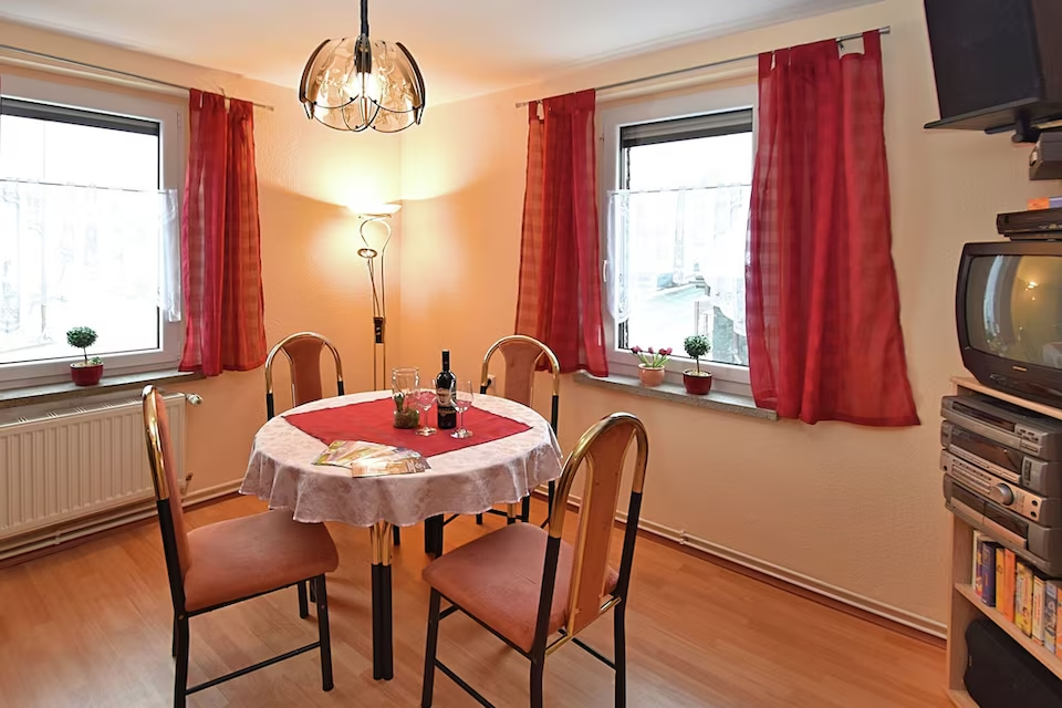 Speisesaal mit Tisch, Stühlen und Fernseher