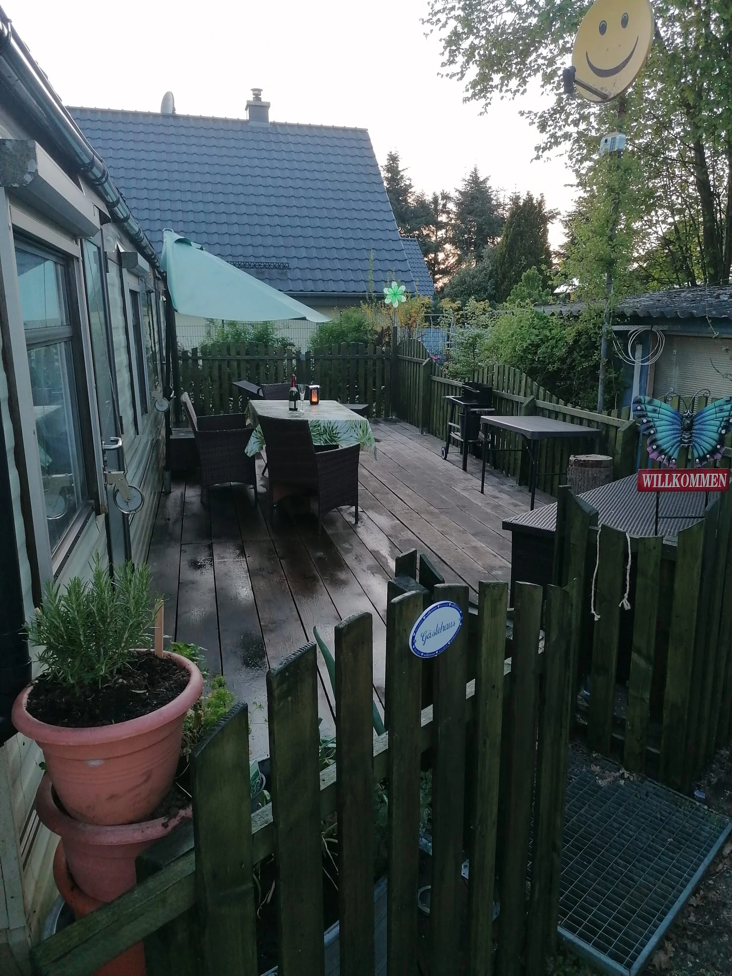 Wohnmobilheim Außenansicht mit Veranda, Tischen und Stühlen