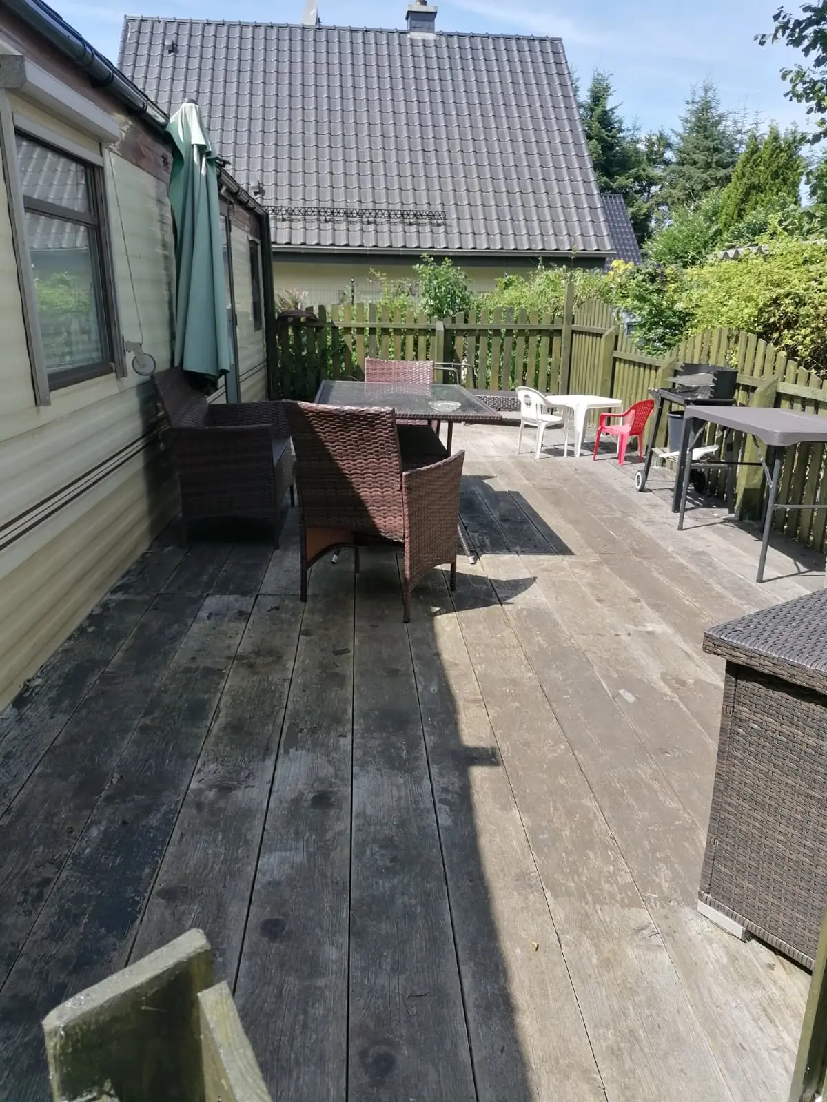 Wohnmobilheim Außenansicht mit Veranda, Tischen und Stühlen