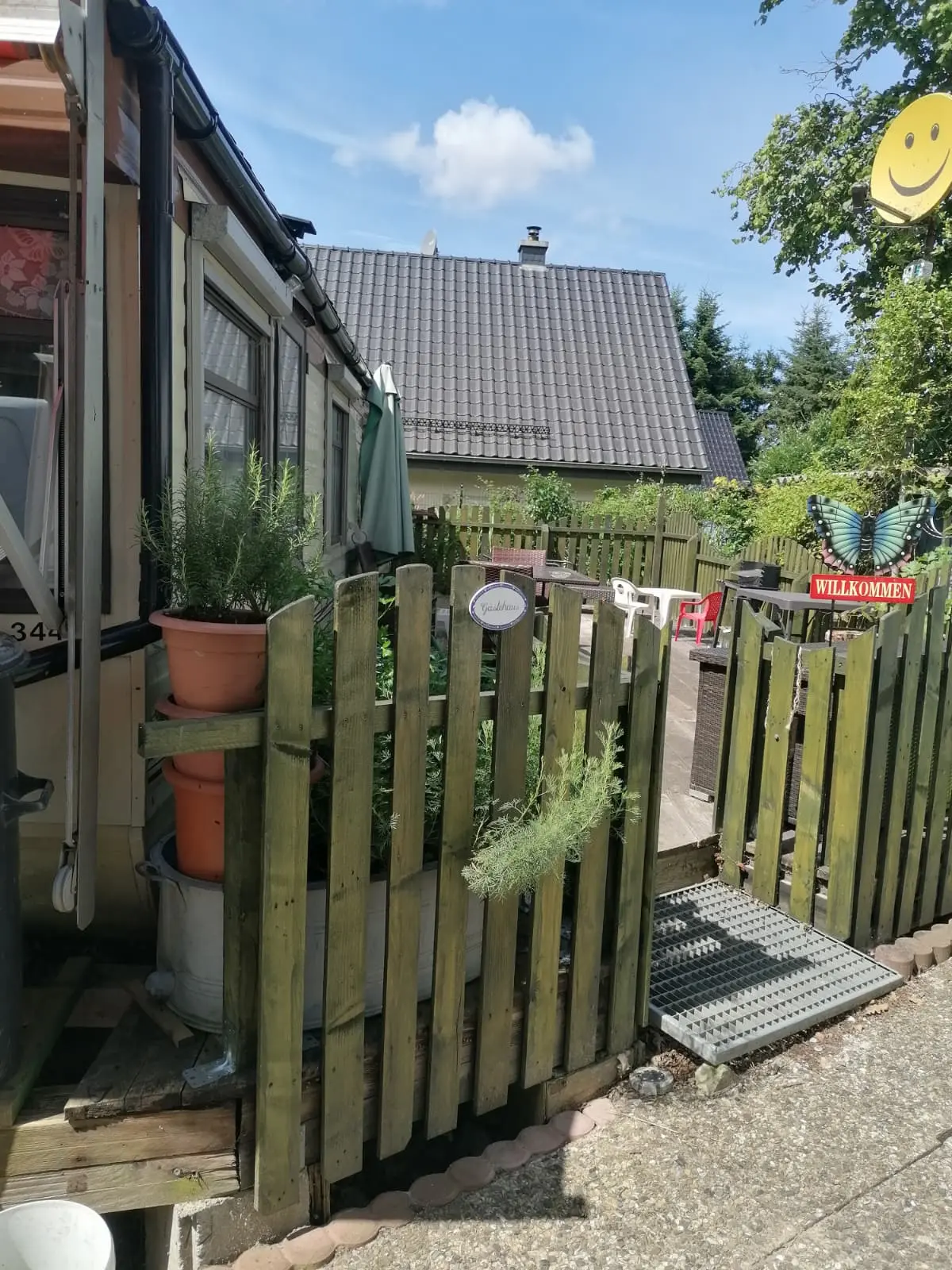Wohnmobilheim Außenansicht mit Veranda und Grillbereich
