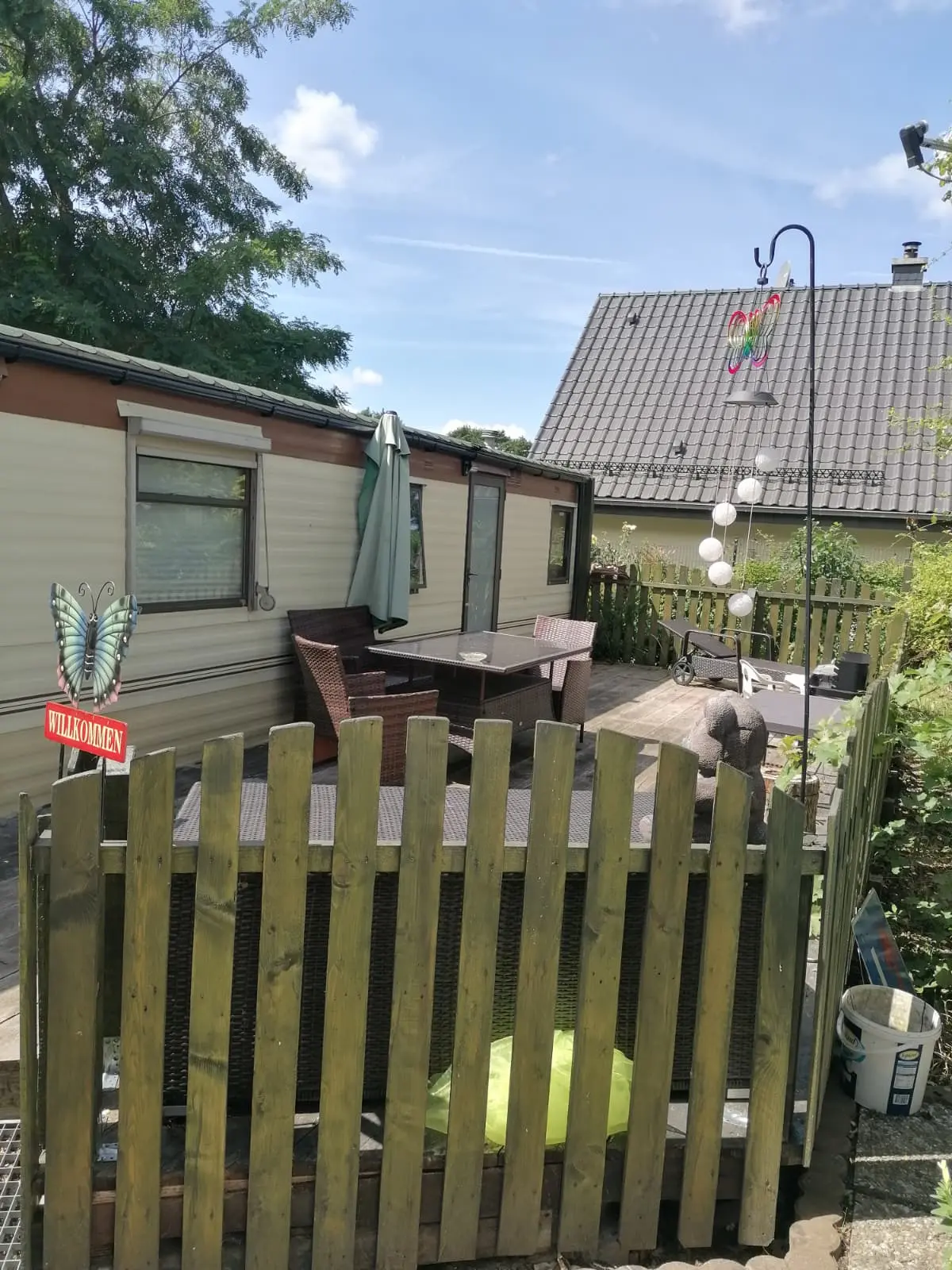 Wohnmobilheim Außenansicht mit Veranda und Grillbereich